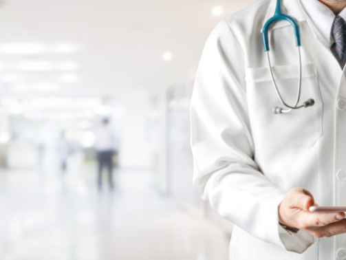 Male doctor using mobile phone at hospital. Medical healthcare and doctor service.